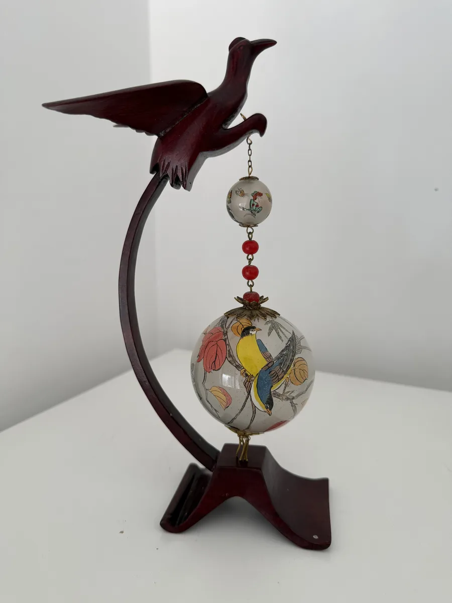 Bola chinesa de vidro pintada por dentro, aves e ramos floridos, sobre base entalhada